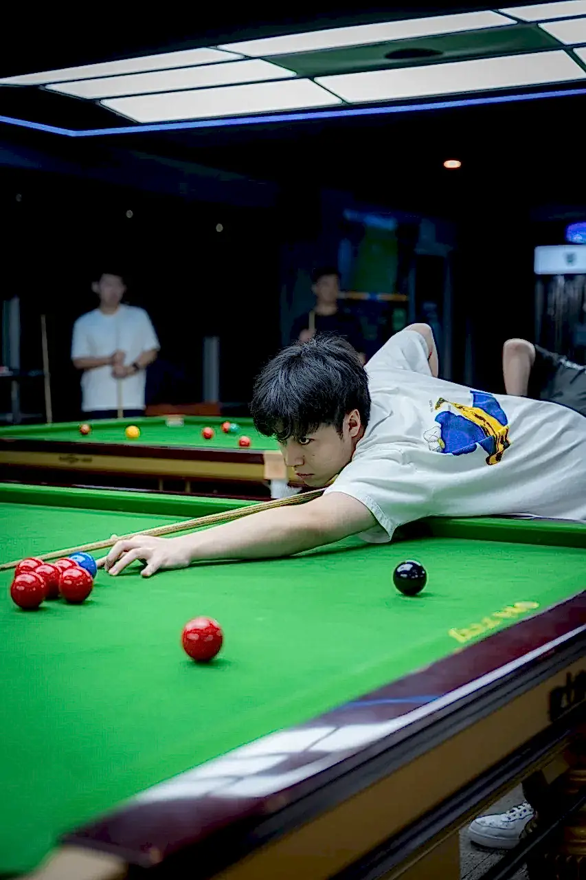 Young player competing at iCUE Billiard Club tournament table